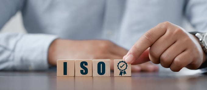 Businessman place the wooden cubes with ISO standards quality control concept, assurance warranty in dark background