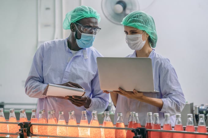 Industrial background of beverage factory production line supervisor and worker working together