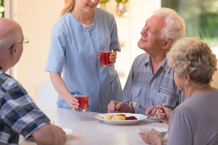 Nurse giving juice to seniors