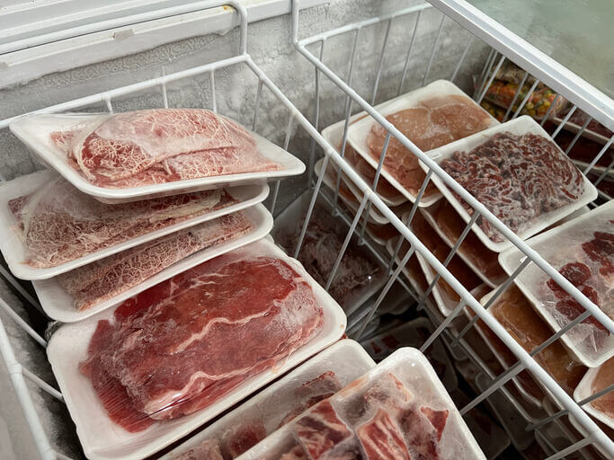 Packaged meet in a deep freezer, some with freezer burn and some without.