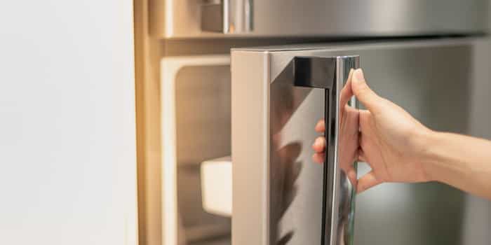 Person opening fridge to check for food expiration. Person opening fridge to check for food expiration.